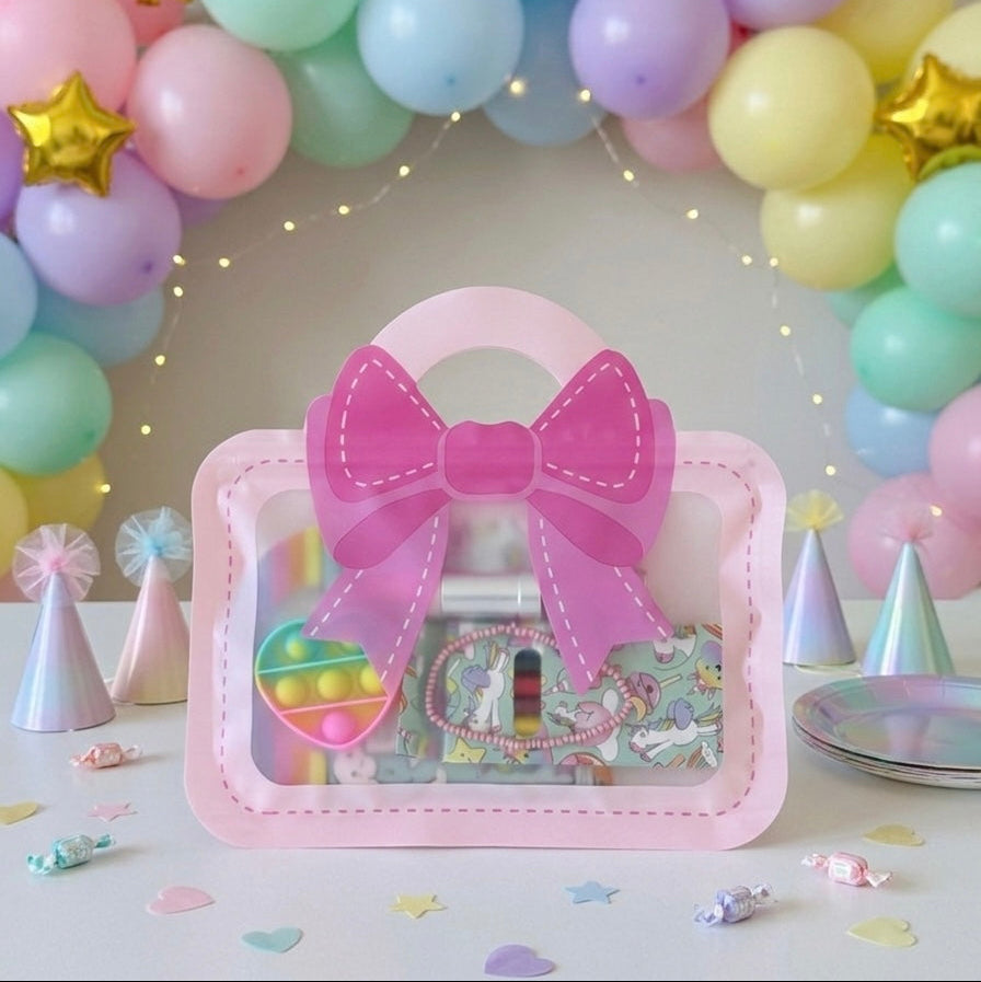 Pink girls party bag UK with bow design filled with party favours displayed against pastel balloon garland backdrop