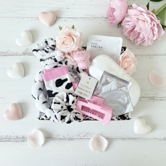 Cow print pamper gift box UK containing cow print headband, scrunchie, socks, pink hair claw clip, pink octopus face brush, Japan Sakura face mask, eye gel pads and sleep eye mask