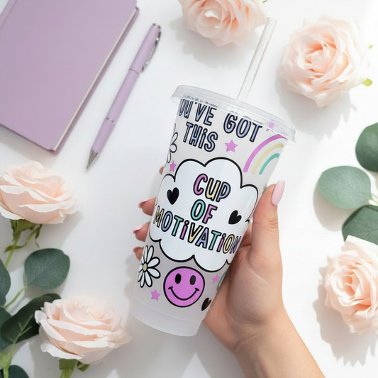 Cup of Motivation 24oz Cold Cup UK held by hand with pastel pink nails, styled with purple diary, lavender pen, pastel pink roses and eucalyptus on white background