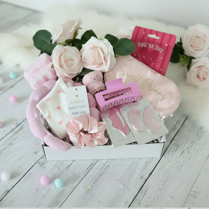 Open mini pink pamper gift box with spa headband, wrist bands, socks, scrunchie, hair claw clip, facial scrubber, lip mask, eye gel pads, sleep mask and facial sheet mask - luxury pamper gift UK