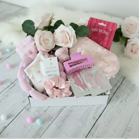 Open mini pink pamper gift box with spa headband, wrist bands, socks, scrunchie, hair claw clip, facial scrubber, lip mask, eye gel pads, sleep mask and facial sheet mask - luxury pamper gift UK