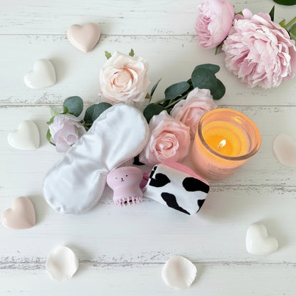 White silk sleep eye mask, pink octopus facial cleansing brush and cow print socks pamper gift UK
