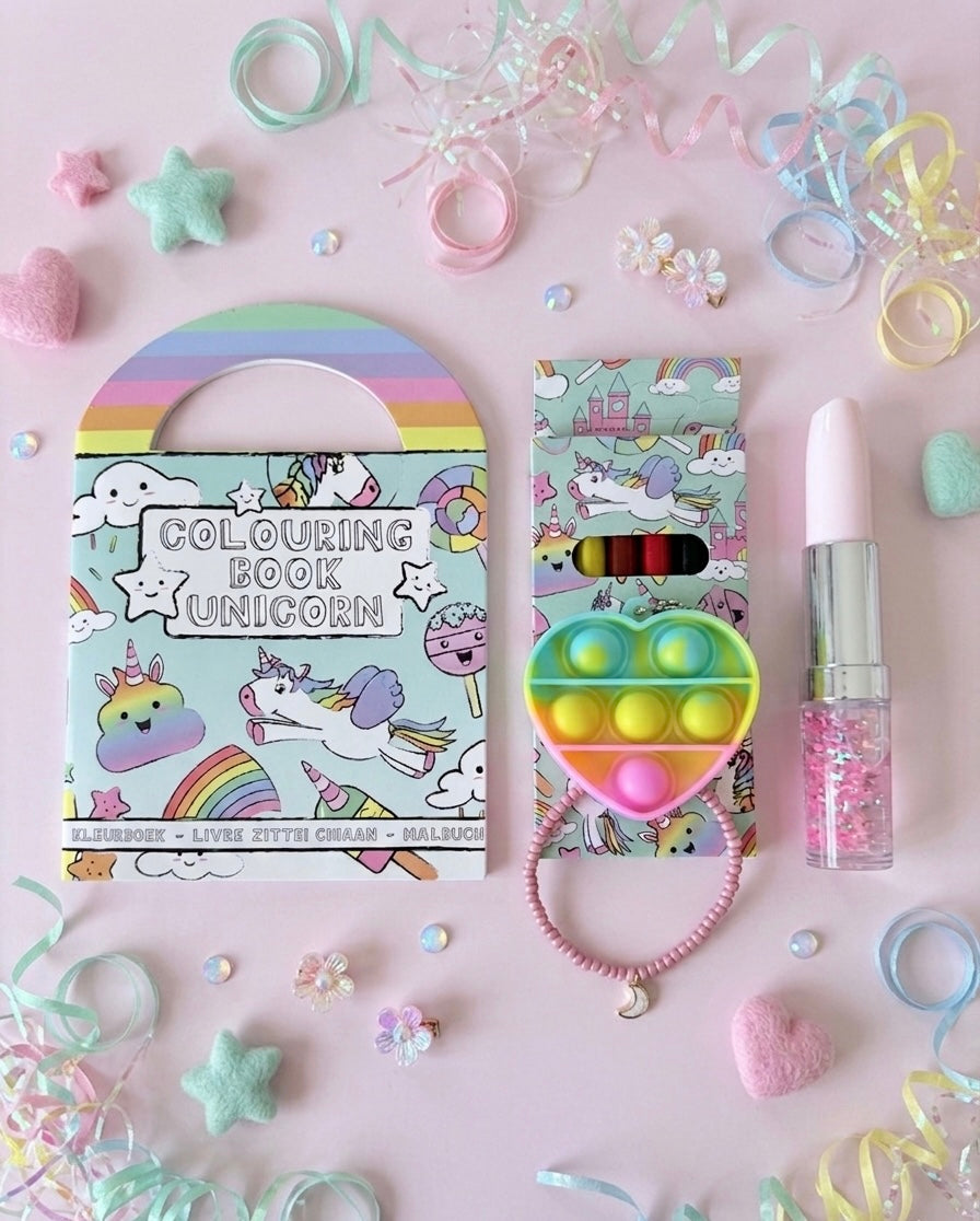 Unicorn party bag contents flatlay including colouring book, pop-it keychain, unicorn colouring book, colouring pencils, lipstick gel pen and bracelet, girls' birthday gift UK